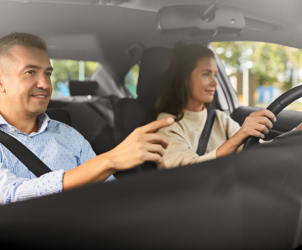 Jeune femme au volant d'une voiture en conduite supervisée avec son accompagnateur